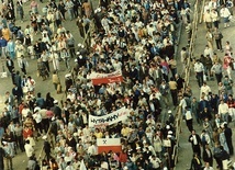 	12 czerwca 1987 r. Trwa pokojowa demonstracja na ulicach Gdańska, zorganizowana po papieskiej Mszy św. na Zaspie. Na fotografii widać tłum ludzi z prosolidarnościowymi flagami i transparentami.