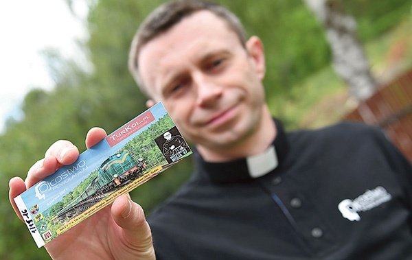 Opiekun duchowy Katolickiego Stowarzyszenia Ojcostwo Powołaniem i wikariusz gubińskiej parafii pw. Trójcy Świętej pokazuje specjalnie wydane bilety na pociąg z Wrocławia do Gubina.