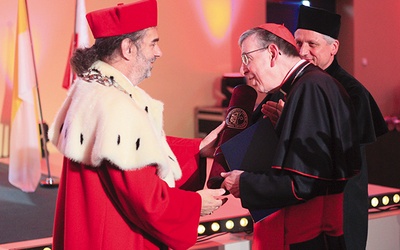 Rektor UO wręcza kardynałowi dyplom doktorski.