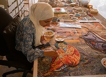 Rinan Barham układa tessery, tworząc postać św. Józefa na mozaice przedstawiającej Boże narodzenie.