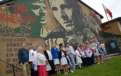 Pamiątkowa fotografia przed muralem z córką legendarnego dowódcy. Anna Maria Anders piąta z lewej.