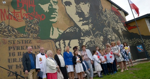 Pamiątkowa fotografia przed muralem z córką legendarnego dowódcy. Anna Maria Anders piąta z lewej.
