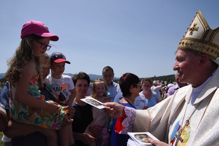 Bp Andrzej Jeż rozdaje modlitewniki rodzinne.