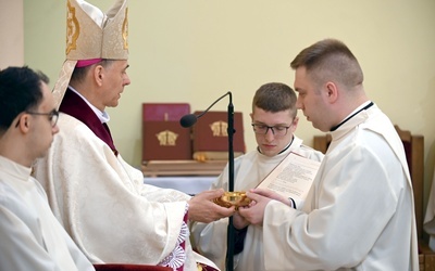 Moment obrzędowy przekazania głębokiej pateny ustanowionemu szafarzowi.