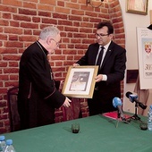 Biskup Jacek Jezierski otrzymuje pamiątkowy znaczek od Wiesława Włodka. 