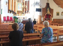 ▲	Wierni modlą się przed obrazem Czarnej Madonny i kopią Całunu Turyńskiego.