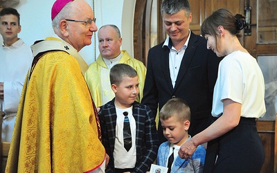 Powitanie arcybiskupa przez jedną z rodzin.