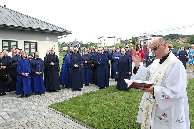 Błogosławieństwo tablicy pamiątkowej, którą umieszczono na ścianie prowadzonego przez siostry przedszkola.