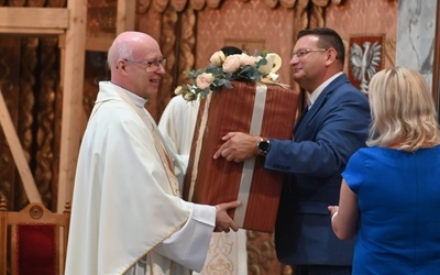 Tomasz Dziurla wręczający odchodzącemu dyrektorowi prezent od wszystkich katechetów diecezji.