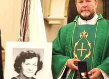 ►	Ksiądz Edward Mazgaj prezentuje odznaczenie przy portrecie parafianki.