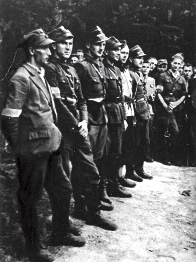 Grupa żołnierzy batalionu partyzanckiego Okręgu Śląskiego AK „Surowiec”. Trzeci od lewej dowódca batalionu por. Gerard Woźnica „Hardy”.  Lipiec 1944 r.