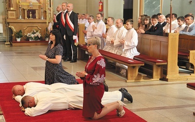 Święcenia diakonatu Bartosza Kaczmarczyka i Krzysztofa Kurpanika w kościele św. Andrzeja Boboli w Leszczynach, w archidiecezji katowickiej. Obok przyjmujących święcenia klęczą ich żony.