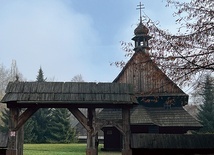 Drewniany budynek  na terenie muzeum wzorem dawnych świątyń otoczony  jest płotem.