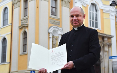 Ksiądz Stanisław Brasse pokazuje dekret Stolicy Apostolskiej.