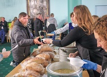 Wolontariusze Domu Nadziei rozdają jedzenie w auli seminaryjnej.