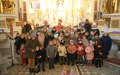 Grupa dzieci wraz ze św. Mikołajem.