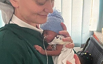	S. Wiktoria Goska trzyma w rękach jedno z uratowanych niemowląt.