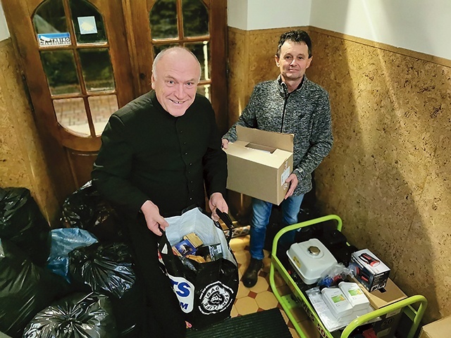 Ksiądz Górowski i Wojciech Czekaj z drobną częścią darów. Z prawej generator zakupiony przez Caritas.