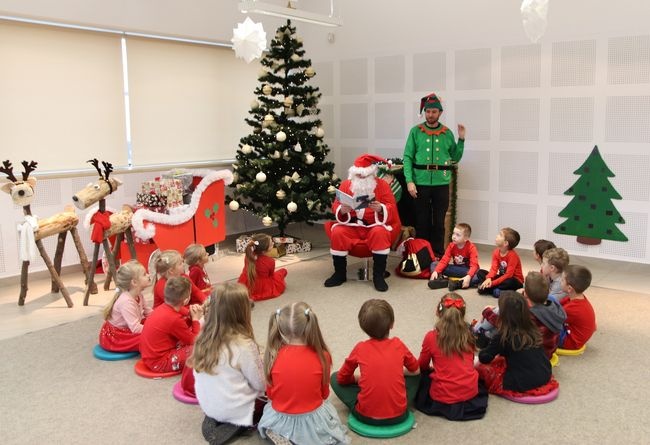 Św. Mikołaj czyta dzieciom.