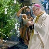 Biskup wnoszący figurkę Dzieciątka Jezus do katedralnej szopki.