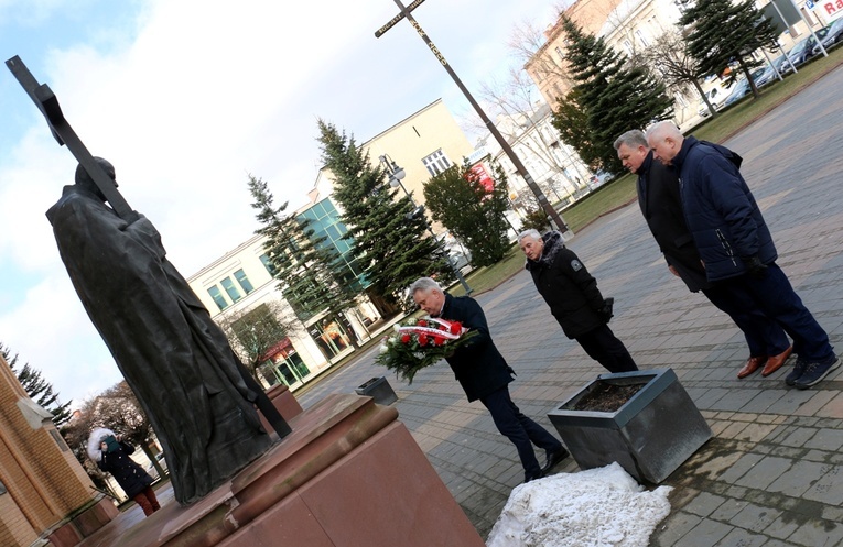 Delegacja PSL składa wiązankę kwiatów przy pomniku papieża Polaka przed radomską katedrą.