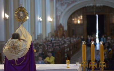 Bp Marek Solarczyk udziela uczestnikom rekolekcji błogosławieństwa Najświętszym Sakramentem.