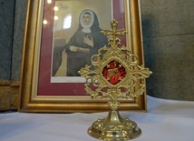 Relikwiarz w paradyskim sanktuarium. W tle wizerunek św. Marii De Mattias, założycielki Adoratorek Krwi Chrystusa.