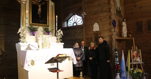 Ks. proboszcz Zbigniew Olszewski z parafianami przy odnowionym ołtarzu.