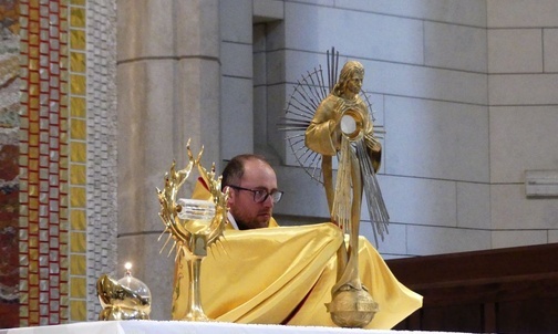 Ks. Marcin Samek błogosławi Najświętszym Sakramentem pielgrzymów na Białych Morzach.