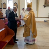 Biskup składający odchodzącemu na emeryturę kościelnemu gratulacje.