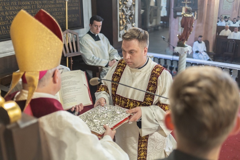 Diakoni przyjęli z rąk biskupa księgę Pisma Świętego.