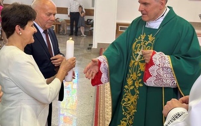 Bp K. Nitkiewcz wręcza świecę parze z Domowego Kościoła.