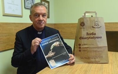 Ks. dyrektor Zbigniew Pietruszka prezentuje plakat i torbę 7. Światowego Dnia Ubogich.