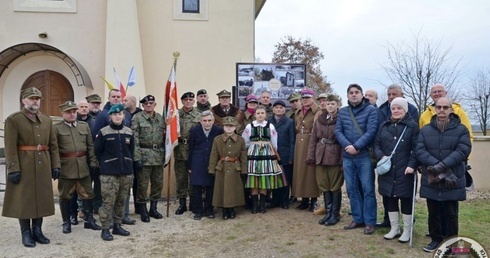 Uczestnicy przed tablicą informacyjną.