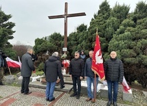 Składanie kwiatów przed krzyżem upamiętniającym ofiary stanu wojennego.