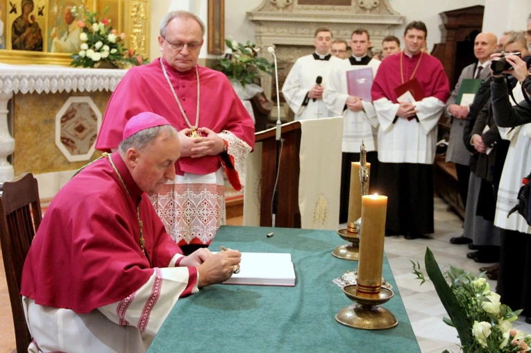 Bp Jeż podpisuje dokumenty synodalne.