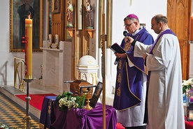 ▲	Biskup modli się  nad urną z prochami zmarłego.