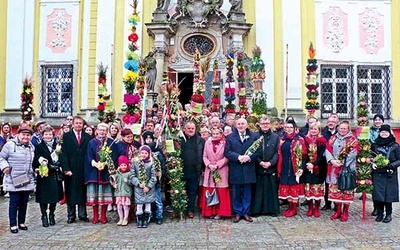 Ręcznie robione kwiaty, ogrodowy bukszpan, słomianki,  zboża i bazie – to wszystko tworzy kolorowe słupy.