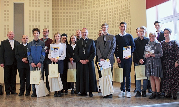 Siedmioro finalistów z bp. Sławomirem Oderem, katechetami i organizatorami. 