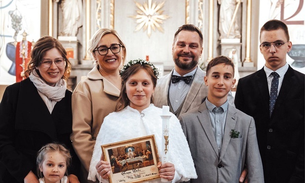 Rodzina Krystyny i Piotra Deków.  Ich córka Teresa niedawno przystąpiła do pierwszej Komunii Świętej.