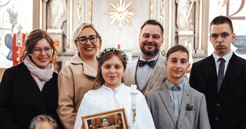 Rodzina Krystyny i Piotra Deków.  Ich córka Teresa niedawno przystąpiła do pierwszej Komunii Świętej.