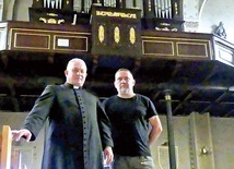 Tutejszy proboszcz i Tadeusz Kalfas pod wyremontowaną balustradą chóru.