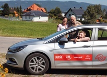 Kuba siedzi za kierownicą, a obok samochodu firmowego „Gościa” stoją mama Beata i tata Bartek.