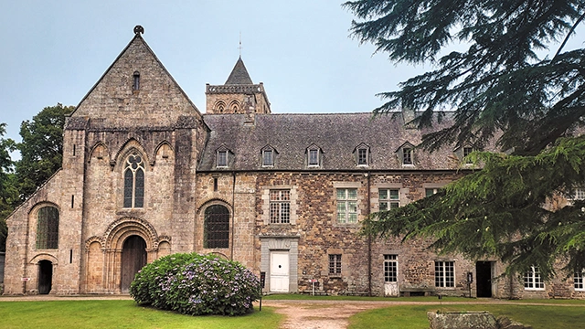 ▲	Portal u wejścia do kościoła jest jeszcze zaokrąglony, romański, ale okno nad nim  już ostrołukowe, gotyckie. 