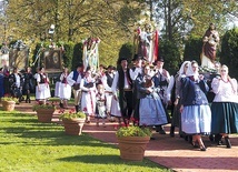 	Parafianie podczas procesji eucharystycznej wokół zabytkowej świątyni.