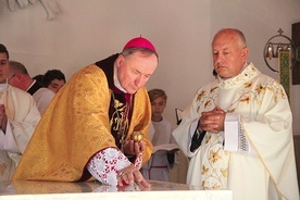 Biskup namaszcza ołtarz, w którym zostały umieszczone relikwie bł. Karoliny. Obok proboszcz parafii ks. Bogdan Lebryk.