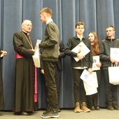 Szymon z Jodłowej otrzymuje nagrodę z rąk abp. Henryka Nowackiego.
