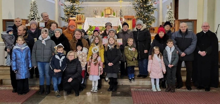 Dzieci z babciami i dziadkami oraz wikariuszem ks. Bartłomiejem Goździewskim.