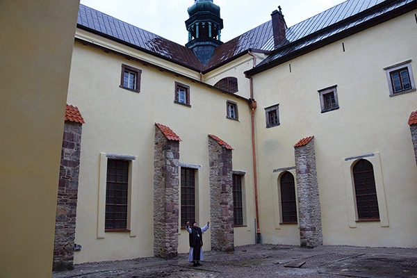 Opat Eugeniusz Augustyn prezentuje efekty prac w wirydarzu.