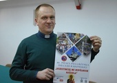 Ks. Krzysztof Bochniak prezentuje plakat pielgrzymki na Jasną Górę.